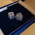 Gros plan détaillé de boucles d'oreilles géométriques en zircons dans un écrin en velours - Style Pavé de Clusters Géométriques (27#)