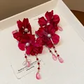 Close-up of red fabric flower earrings with white pearls and pink teardrop charms - Teardrop Pendant / Rose Red