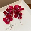 Close-up of red fabric flower earrings with pearls and heart-shaped drops - Heart Pendant Style / Rose Red