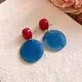 Dettaglio di orecchini tondi in acrilico con contrasto rosso e blu marmorizzato - Contrasto Rosso e Blu (HE28425)