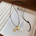 Vue détaillée d'un collier pendentif cheval doré dans un coffret à bijoux en bois - Collier / Or