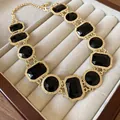 Detailansicht einer Vintage-Goldhalskette mit facettierten schwarzen Steinen - Halskette / Schwarz