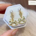 Detaillierte Nahaufnahme von vergoldeten Schaukelpferd-Ohrringen mit Perlen und Zirkon. - Schaukelpferd Stil (HE30354) / 925 Silberstecker / Gold