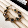 Nahaufnahme einer goldenen Vintage-Kette mit blauen Kristallblüten und Juwelen - Armband (2)