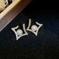 Detailed view of elegant gold geometric earrings with a central pearl and pavé. - Rhombus Pearl Stud Earrings / Gold-Beige