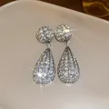 Dettaglio di orecchini a goccia in strass argentati brillanti con riflessi di luce - Stile Goccia d'Acqua / Argento