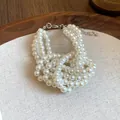 Primo piano di un elegante braccialetto di perle vintage francese su sfondo di lino - Stile Francese Multi-filo (13#) / Bianco