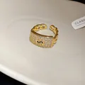 Macro detail of a gold chain ring featuring a zircon-encrusted square face and open band. - Square Chain Splicing Style (WR491) / Gold