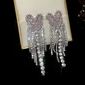 Close-up of sparkling pink zircon butterfly earrings with long rhinestone tassels - Extra Long Tassel