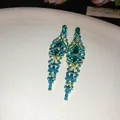 Primo piano di orecchini pendenti in stile palazzo con strass blu e verdi scintillanti. - Perno in argento-Blu