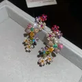 Close-up of sparkling multi-color zircon flower earrings in a grey jewelry box. - Stud Earrings Clip (HE9992-1)