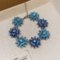 Detailed view of a vintage-style bracelet with blue enamel flowers and sparkling rhinestones. - Bracelet