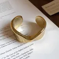 Detailed close-up of polished golden twisted cuff bracelet with an elegant wavy design. - Twisted Wave Style (1)