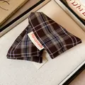 Close-up of a brown plaid fabric triangle hair claw clip with a white Handmade tag - Triangle Shark Clip / Dark Coffee