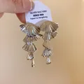 Macro detail of elegant silver-toned multi-layered fan-shaped dangling earrings on a tag - Multi-Layer Fan Style (HE21547) / Silver