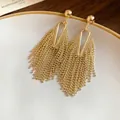 Detailed close-up of vintage gold fringe tassel earrings featuring a geometric bead design - Gold