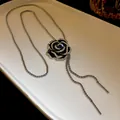 Vista dettagliata di una collana con ciondolo a camelia in smalto nero e accenti di zircone - Stile Camelia Nera (Collana) / Nero