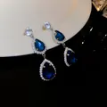 Close-up view of elegant dark blue teardrop crystal earrings with sparkling silver pavé setting - Earrings (HE16003-HN4381) / Blue