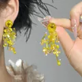 Detail view of yellow shell flower tassel earrings with intricate beaded fringe design - Style 1
