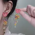 Detailed close-up shot of sweet pink heart earrings with colorful cascading beaded tassels - Style 40 Yellow Floral