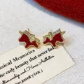 Close-up of red enamel horse stud earrings with sparkling rhinestone accents. - 4# Gold Red