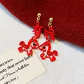 Detail showing red horse-shaped earrings with 'Wealth' Chinese character design - 1# Gold Red