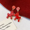 Close-up of vibrant red pony earrings with gold traditional studs on a red knitted background - 2# Gold Red