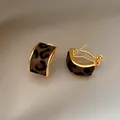 Detail view of elegant C-shaped gold hoop earrings with leopard print textured inlay. - Gold-Coffee Leopard Print