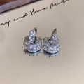 Close-up of luxury CZ paved U-shaped bag earrings with sparkling gold plating - U-shaped Bag Design Huggie / Silver