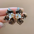 Detailed view of vintage brown enamel flower earrings with crystal centerpieces - Brown