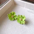 Macro detail of lime green flower stud earrings with delicate sparkling stamen center. - Green