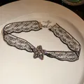 Detail shot of black lace choker necklace with a sparkling rhinestone star pendant. - Star / Black