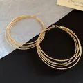 Detailansicht goldener mehrlagiger Creolen im Vintage-Stil mit strukturierter Oberfläche - Gold