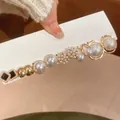 Close-up of elegant gold hair clip with white pearls and black square accents - Style 14 Silver Post
