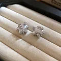 Close-up detail of elegant star-shaped stud earrings with zircon and pearlescent finish. - Silver Needle / Silver
