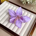 Détail d'une barrette à cheveux fleur de lys violette montrant la texture des pétales en tissu - Pince à Bec de Canard Fleur de Lys / Violet