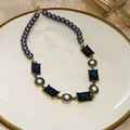 Detailed macro view of vintage necklace with blue stones and dark grey pearls. - Necklace - Gold - Blue