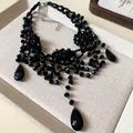 Gros plan détaillé du collier multicouche en cristal noir avec pendentif goutte élégant - Collier Multicouche Pendentif Fleur et Goutte / Argent-Noir