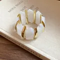 Nahaufnahme der weißen Acryl-Diamantsegmente und Goldakzente an diesem elastischen Armband. - Weiß