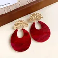 Close-up of retro red marbled U-shape earrings with hammered gold metal details - Gold-Red