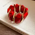 Detailaufnahme eines roten marmorierten Acryl-Armbands mit edlen Goldelementen - Rot