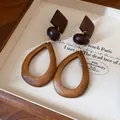 Primer plano de pendientes de madera con forma de gota en un joyero de estilo vintage - Estilo Gota Hueca Geométrica / Marrón