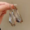 Detailed view of gold irregular twisted metal earrings with a unique bark surface - Ear Hook Style / Light Coffee Gold