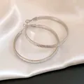 Detail view of silver hoop earrings featuring a unique corrugated twill texture pattern. - Diameter 50mm / Silver