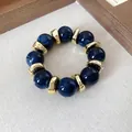 Dettaglio dei grani in acrilico blu marmorizzato e distanziatori dorati del bracciale. - Bead Splicing (HB4541) / Blu