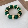 Dettaglio del bracciale con perle in acrilico verde marmorizzato e distanziatori dorati. - Bead Splicing (HB4541) / Verde