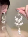 Macro view of French style flower and pearl dangle earrings with silver needles - Style 2 / Gold-White