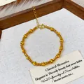 Close-up of gold-plated beaded bracelet with elegant textured finish on a rustic display. - Gold Frosted Bead Style (3#)