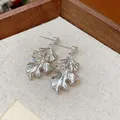 Detailed macro view of elegant silver leaf-shaped earrings featuring a unique wrinkled texture - Silver