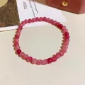 Detailed macro view of a pink strawberry quartz beaded bracelet on a warm beige backdrop - Solid Color Beaded Style (Style 73) / Pink